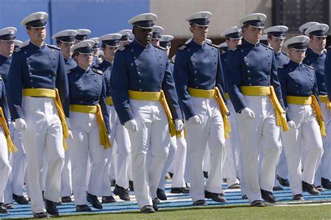 Air force graduation - Spaced 8 feet apart, United States Air Force Academy cadets celebrate their graduation as a team of F-16 Air Force Thunderbirds fly over the academy on April 18, 2020 in Colorado Springs, Colo.